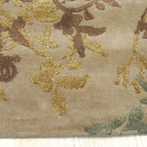 Textured tan rug featuring raised gold, brown, and sage floral patterns on a light wooden floor.