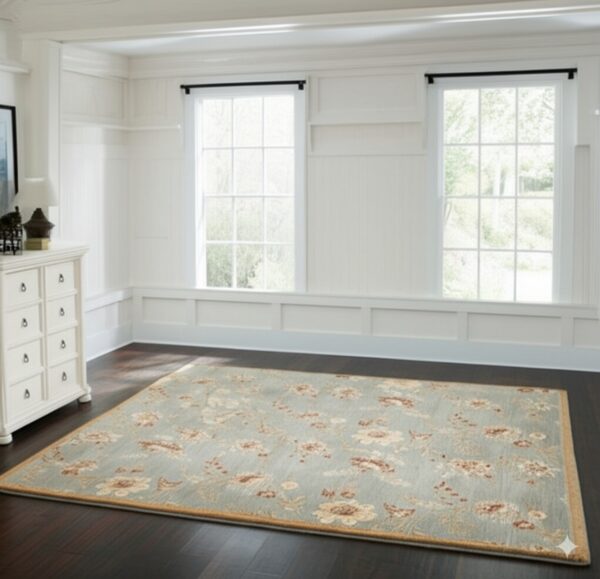 Floral patterned rug in blue-green, cream, and brown colors lies on dark wood flooring.