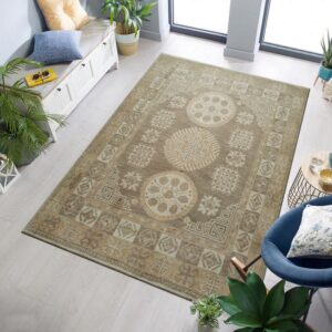 Neutral tan rug with large geometric medallions lies on pale wood floors next to a blue armchair.