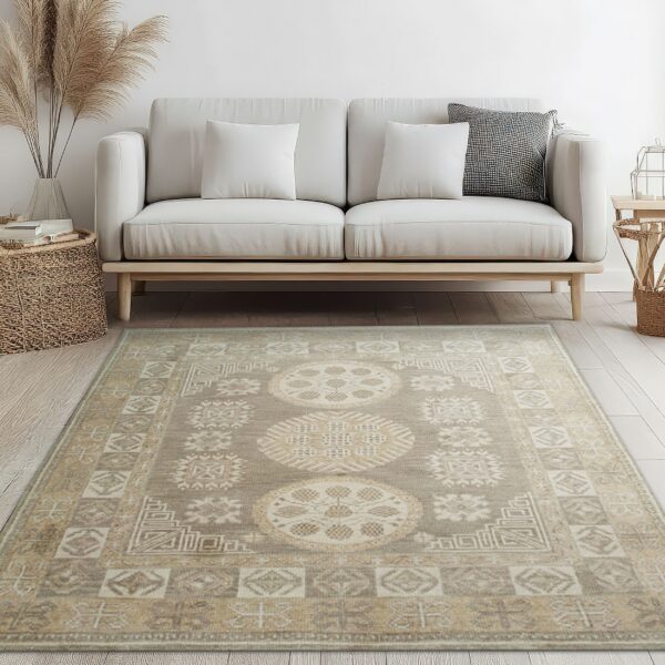 Taupe and cream traditional rug featuring three large medallions beneath a neutral sofa on light wood flooring.