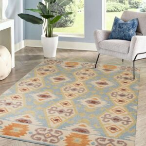 A geometric low-pile rug in blue, cream, and orange accents a room with a gray chair and window.