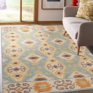 Ikat-style rug in blue, cream, gold, and rust colors under a light gray sofa near a large window.