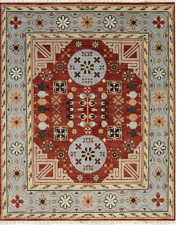 Rust-colored rug with geometric medallions and wide borders in pale blue and cream.