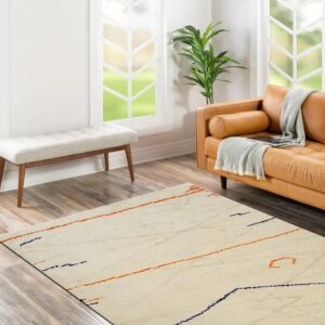 Cream textured rug with scattered orange and navy blue abstract marks in a bright living room.