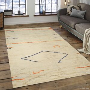 Cream shaggy rug with orange and blue abstract lines on wide distressed wood planks next to a gray sofa.