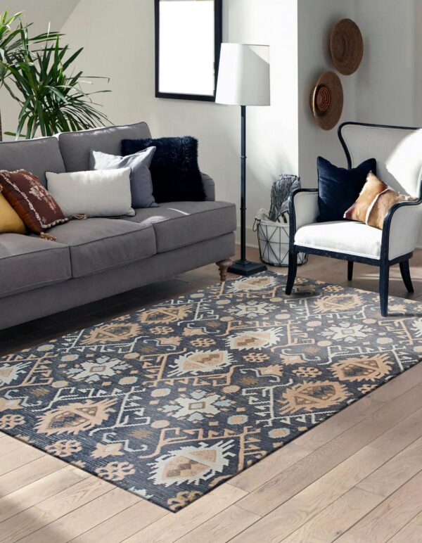 Navy and tan tribal rug anchors a living room with a gray sofa, white armchair, and wood floor.