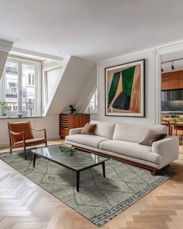 A textured gray rug with black geometric lines lays on light herringbone flooring beneath a cream sofa.