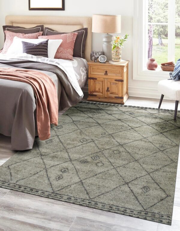 A medium-pile gray and charcoal diamond pattern rug beneath a bed in a bright bedroom setting.