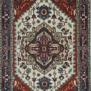 Ivory traditional rug with navy and rust red geometric medallion and floral border motifs.