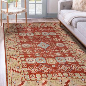 Red and beige traditional rug with blue geometric patterns sits on wood floors near a sofa.