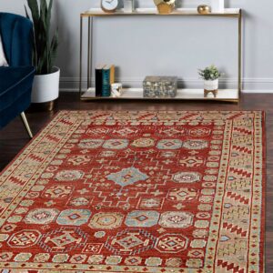 Terracotta rug with tan and light blue traditional motifs anchors a room with dark wood floors.