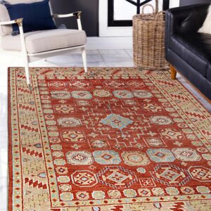 Traditional red, beige, and blue rug displayed on marble tile next to an upholstered armchair.