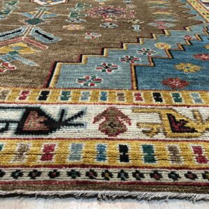Textured brown rug featuring dense geometric patterns and wide borders in blue, yellow, and cream.