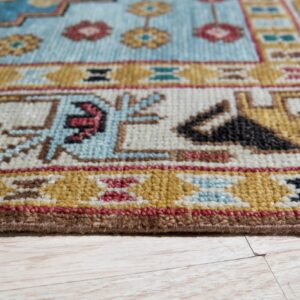 Low-pile rug with geometric patterns in blue, gold, cream, and red resting on light wood flooring.