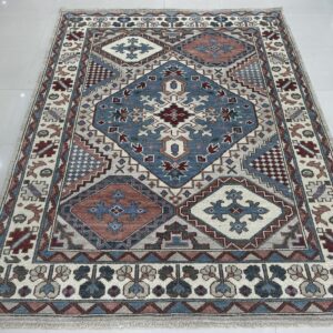 A blue, rust, and cream geometric patterned area rug resting on shiny white floor tiles.