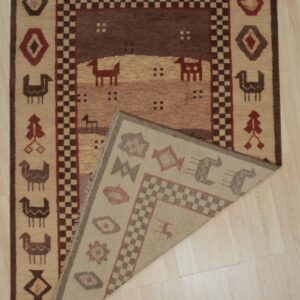Brown and beige rug featuring geometric and stylized animal designs, displayed folded on a light wood floor.