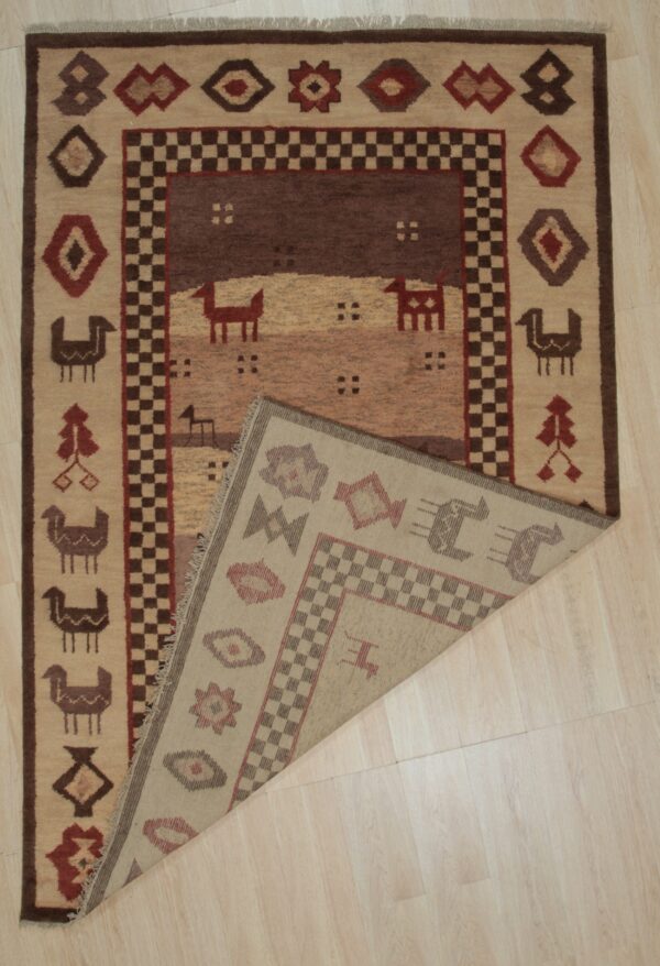 Brown and beige rug featuring geometric and stylized animal designs, displayed folded on a light wood floor.