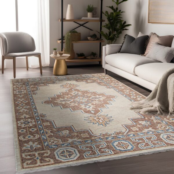 Geometric cream rug with rust and blue accents anchors a living area with a white sofa and dark wood floor.
