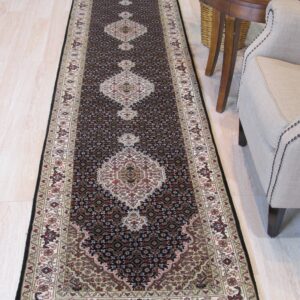 Black and beige traditional runner rug on light wood flooring near a nailhead-trimmed upholstered armchair.