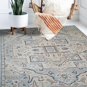 Light blue and beige traditional rug placed beneath a wicker chair and a tall potted plant.