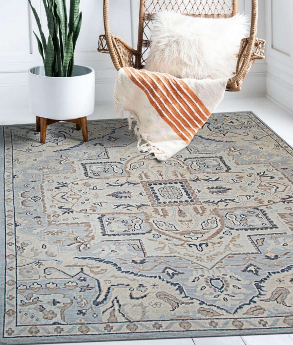 Light blue and beige traditional rug placed beneath a wicker chair and a tall potted plant.