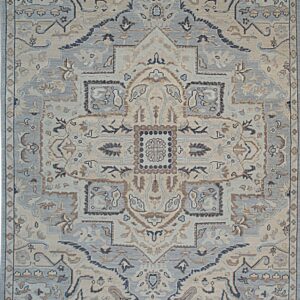 Traditional rug with central medallion, using slate blue, beige, and brown colors, finished with fringe.