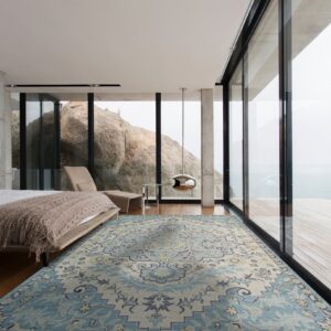 Blue and cream traditional rug on a wood floor in a modern bedroom with large glass walls.