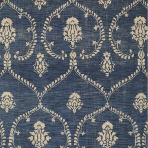Blue rug with variegated texture and a repeating cream floral motif and dotted trellis pattern.