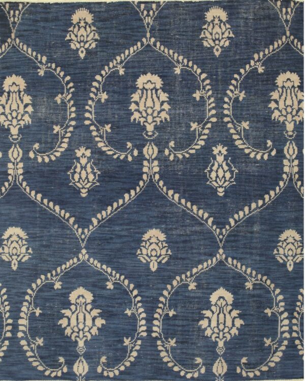 Blue rug with variegated texture and a repeating cream floral motif and dotted trellis pattern.