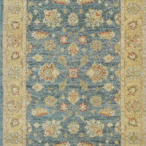 Muted blue runner rug with a traditional repeating floral pattern and wide tan borders.