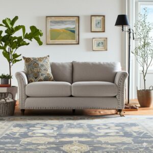 Gray and cream distressed rug sits beneath a neutral sofa on hardwood flooring.