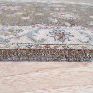 A close-up view of the thick, brown pile edge and floral border pattern on light wood floor.