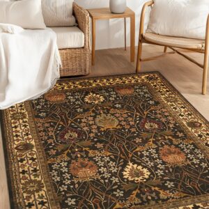 Dark brown floral rug with gold and rust accents laying on wood floor next to natural rattan furniture.