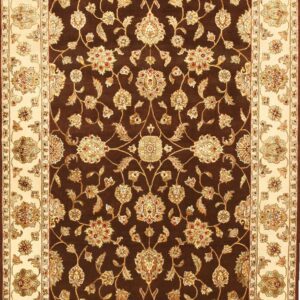 Brown and cream rug displaying an elaborate traditional floral vine pattern in the dark field and wide border.