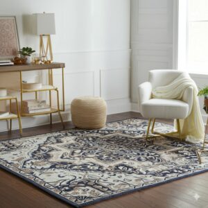 Ornate navy blue, tan, and cream patterned rug anchors a bright room with a white chair.