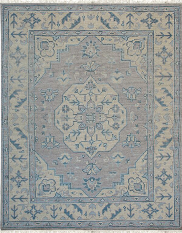 Low-pile rug featuring a central geometric medallion and borders in muted lilac, cream, and slate blue.