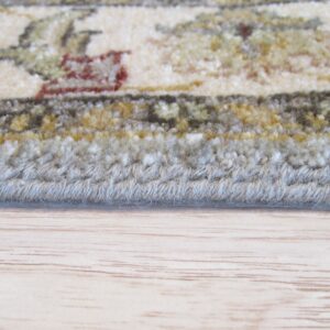 Close-up of a floral rug edge showing cream, green, and rust patterns, resting on light wood flooring.