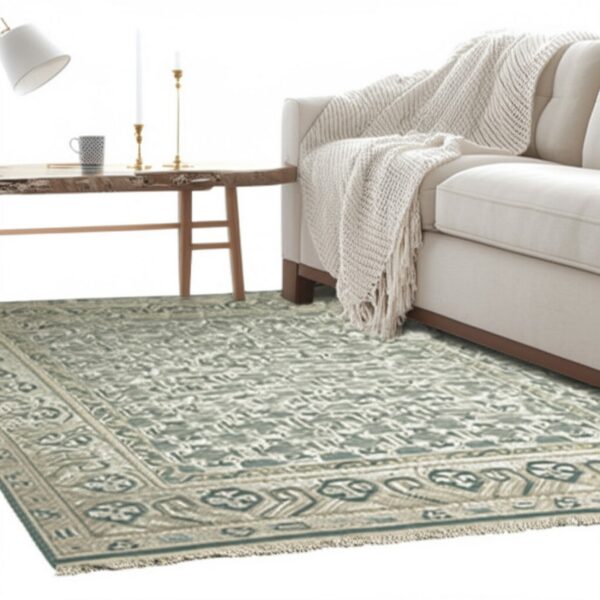 Seafoam green and beige traditional rug under a cream sofa, next to a wood side table and floor lamp.