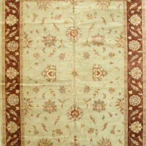 Pale sage green area rug displaying a detailed floral medallion pattern and wide red-brown ornamental borders.
