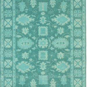 Traditional rug in varying shades of teal and aqua with large stylized floral motifs and geometric borders.