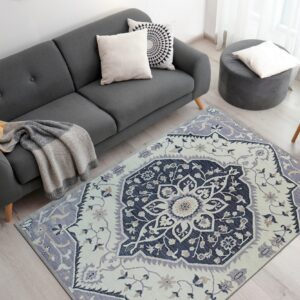 Navy and lavender traditional rug centering a gray sofa area on light wood flooring.