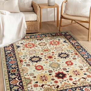 An ivory floral medallion rug with red and navy accents is centered on a wooden floor near wicker seating.