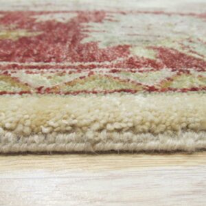 High-pile rug edge in cream, red, and sage patterns rests directly on light wood flooring.