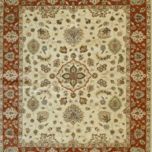 Traditional rug featuring a detailed multicolored floral pattern on a cream field and a wide rust-colored border.