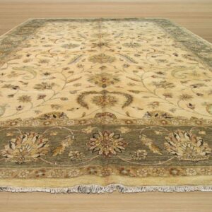 Traditional cream area rug with detailed floral patterns and olive green borders on a light wood floor.