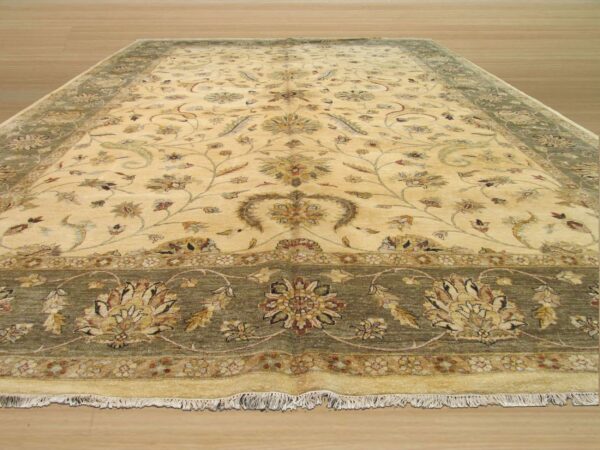 Traditional cream area rug with detailed floral patterns and olive green borders on a light wood floor.