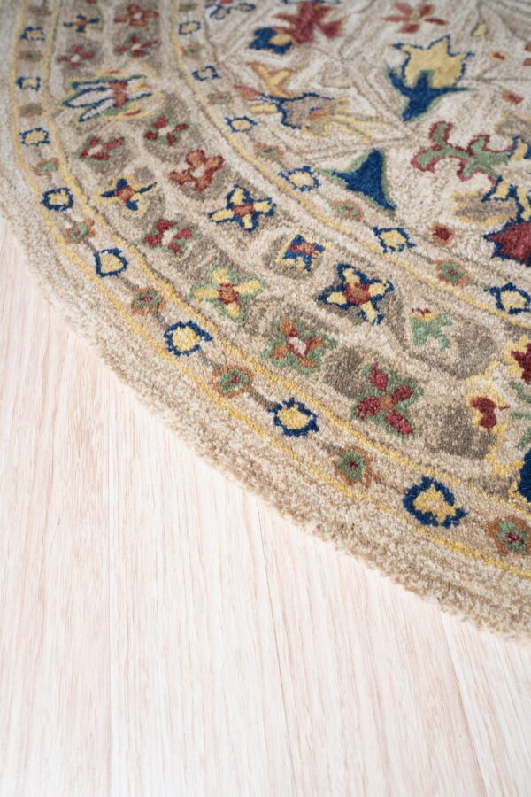 Textured beige round rug detail with colorful red, blue, and yellow patterns on light wood floors.
