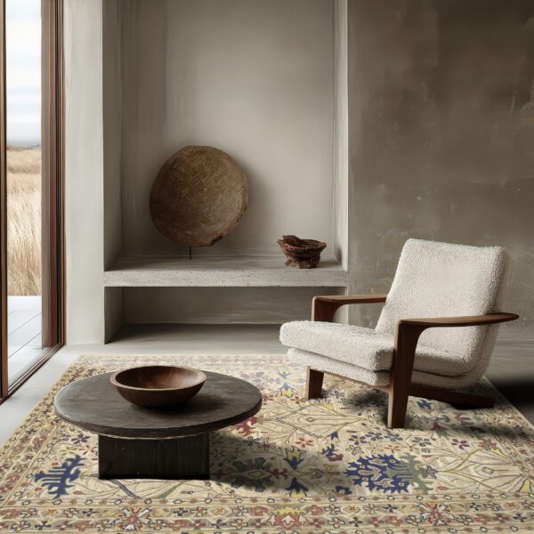 Traditional beige rug with colorful floral motifs grounds a modern space with a textured cream chair and dark table.
