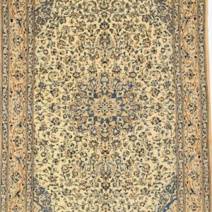 Ornate low-pile rug with blue and tan floral designs on an ivory background and visible fringe.