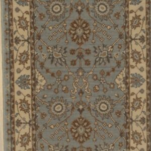 Long dusty blue runner with repeating cream and brown floral motifs rests on light wood planks.
